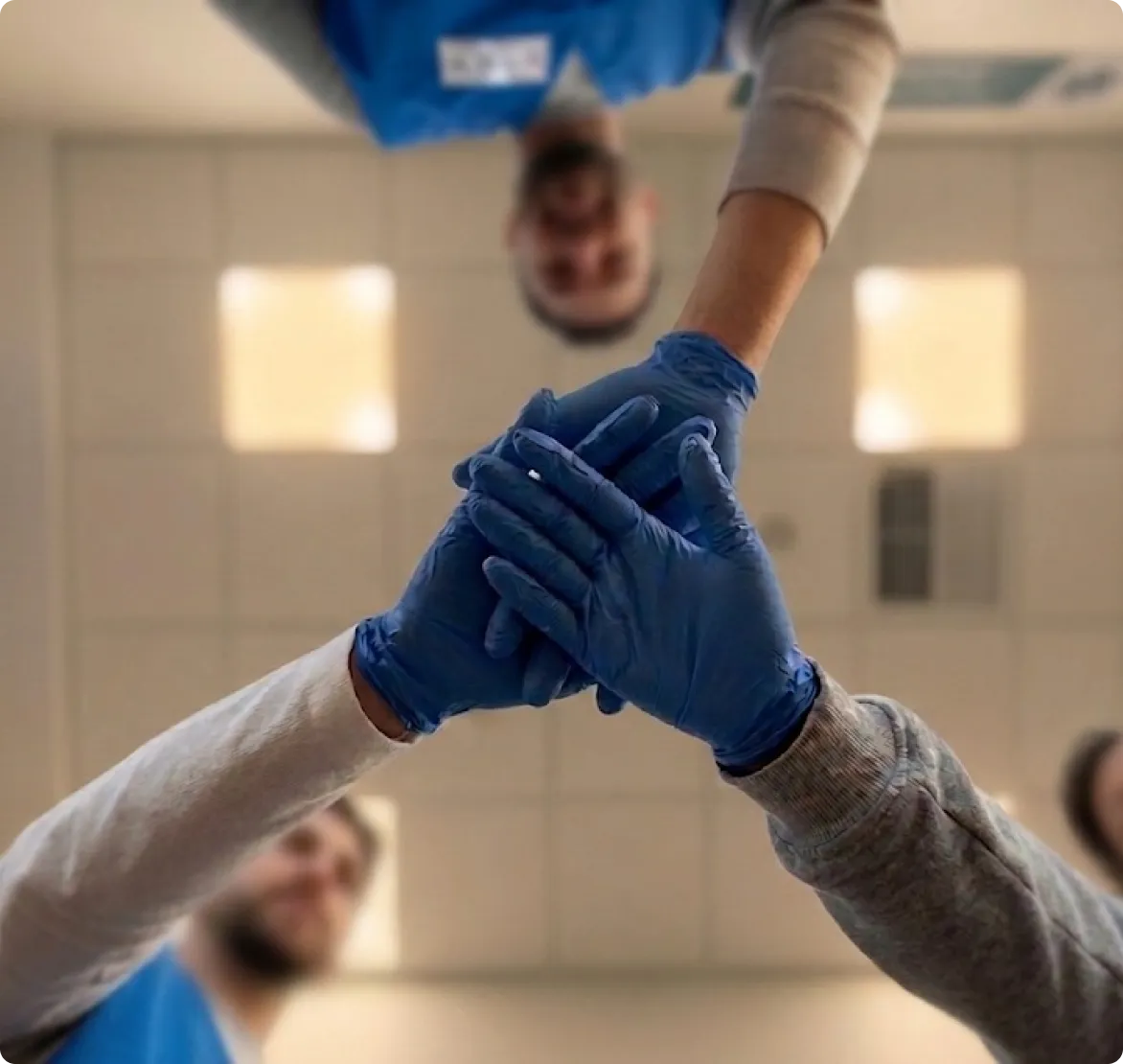 Voluntarios uniendo sus manos en señal de equipo
